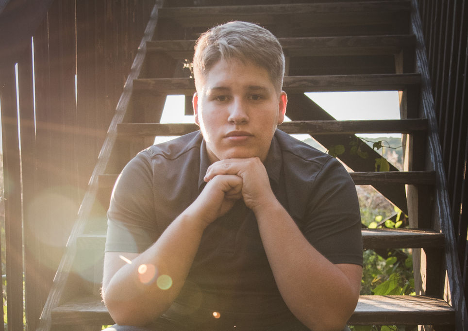 teenager sitting on steps hands under chin outdoors