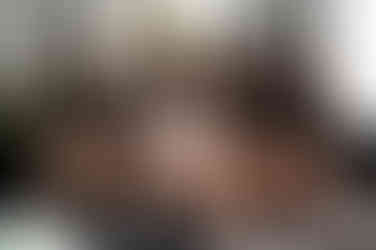 women in silk pajamas sitting on couch looking at each other smiling The Tin Smith in Madison Wisconsin