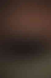 groom and groomsmen in black suits posing with brown wall behind them at Whispering Pines Event Center in Poynette Wisconsin