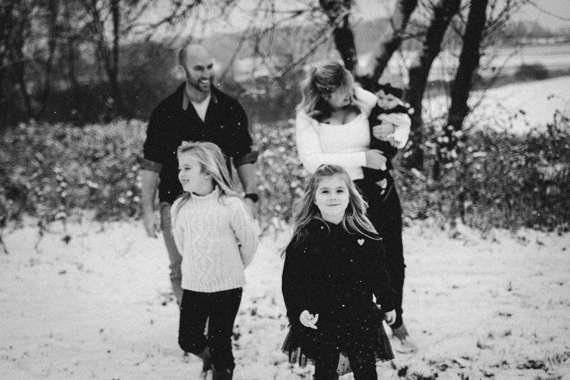 family of two parents and three small girls walking in the snow in Deerfield Wisconsin