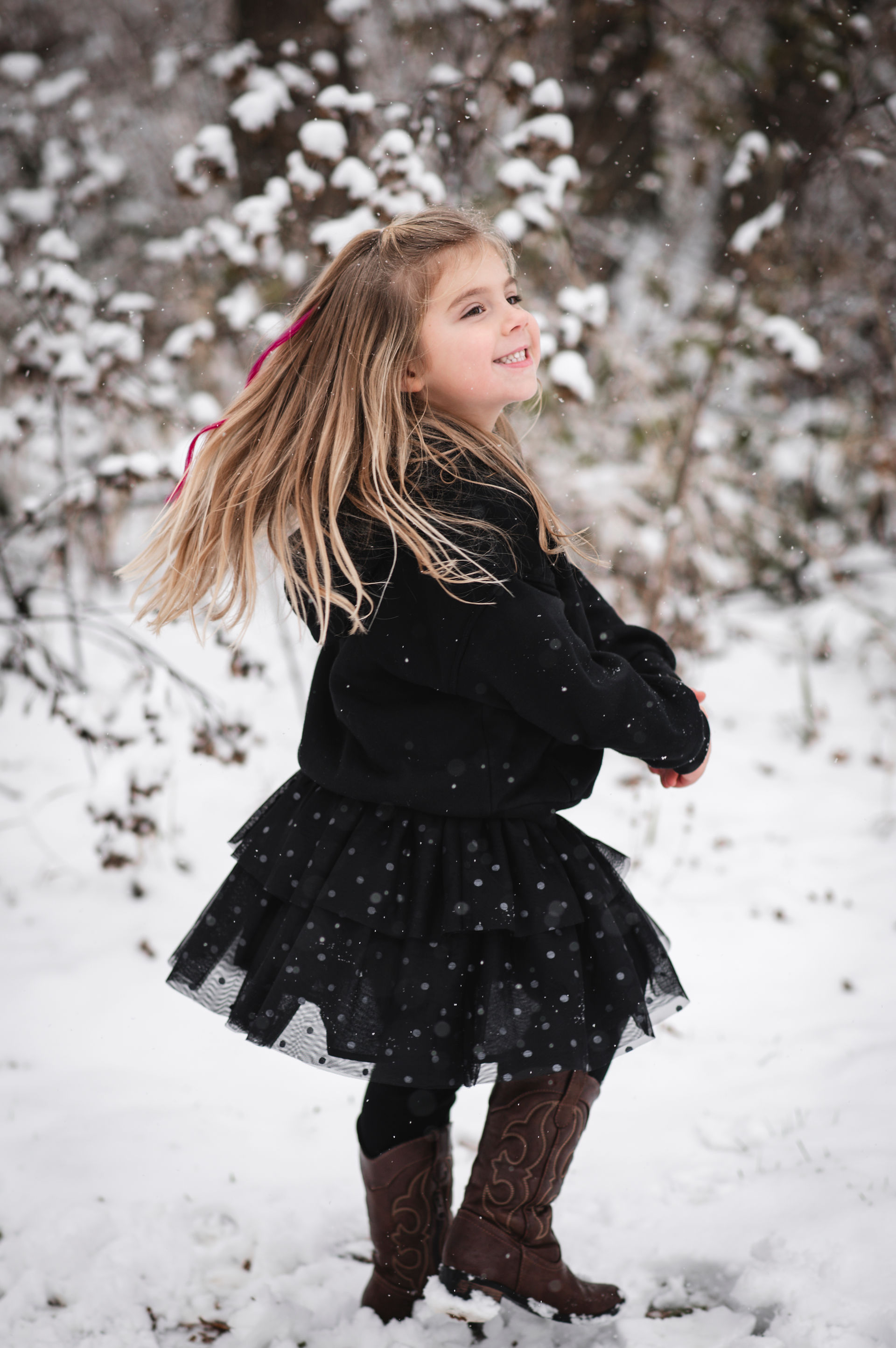 little blonde girl playing and dancing in the snow in Deerfield Wisconsin