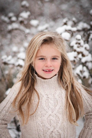 little blonde girl with long hair smiling in the snow in Deerfield Wisconsin