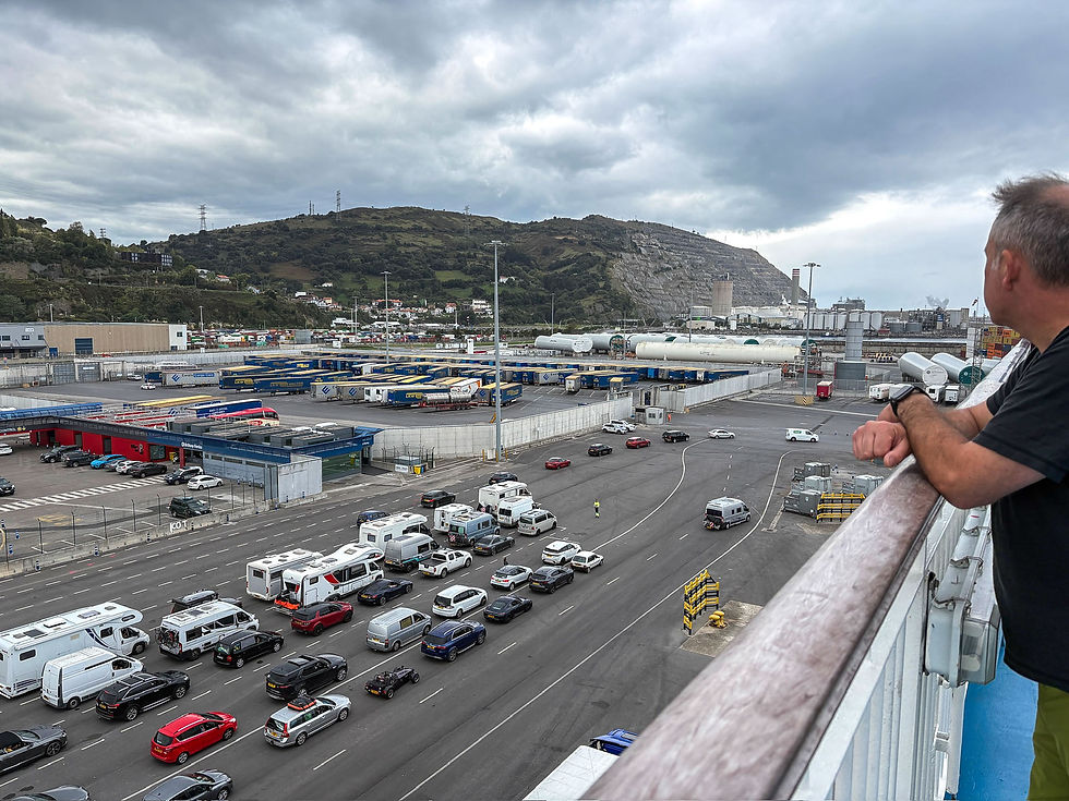 Person observing a busy industrial port with parked cars and trucks. Overcast sky, green hills, and multiple lanes create a bustling scene.
AvVida.co.uk Adventure Motorcycle Travel with Turkana Gear
We were showered and up on deck, whilst many people were still waiting to board.
Puerto de Bilbao/Bilbaoko Portua, Zierbena, Costa Vasca, Spain