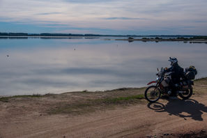 Kelvin on his DR650 looking out over a lake in Uruguay