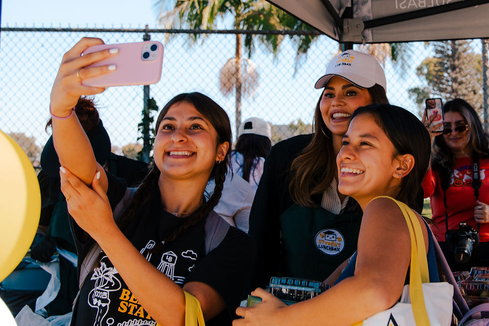 Chrissy Teigen and students capture a joyful moment at the Student LunchBox Mobile Market event in collaboration with CSU Long Beach.
