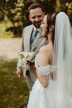 ächelndes Brautpaar unter freiem Himmel, das in einem intimen Moment festgehalten wird – authentische Hochzeitsfotografie vol