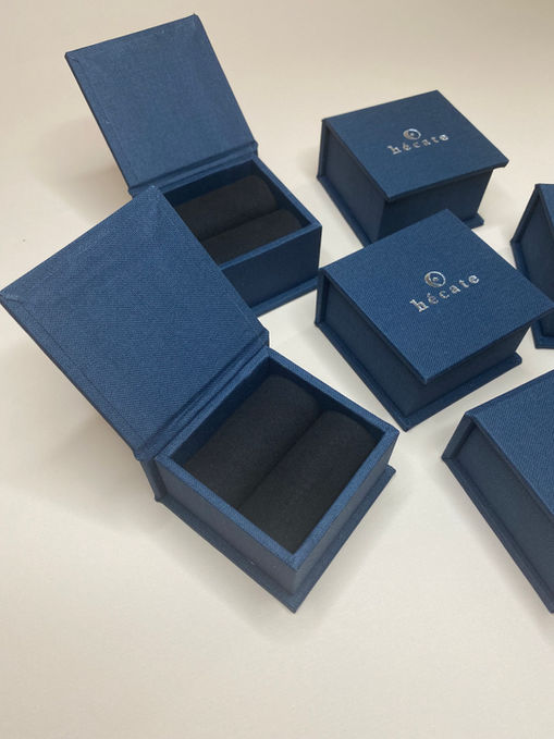 Caixa para joia no tamanho pequeno azul marinho com suede preto no interior. Aplicação de hot stamping na cor prata na tampa