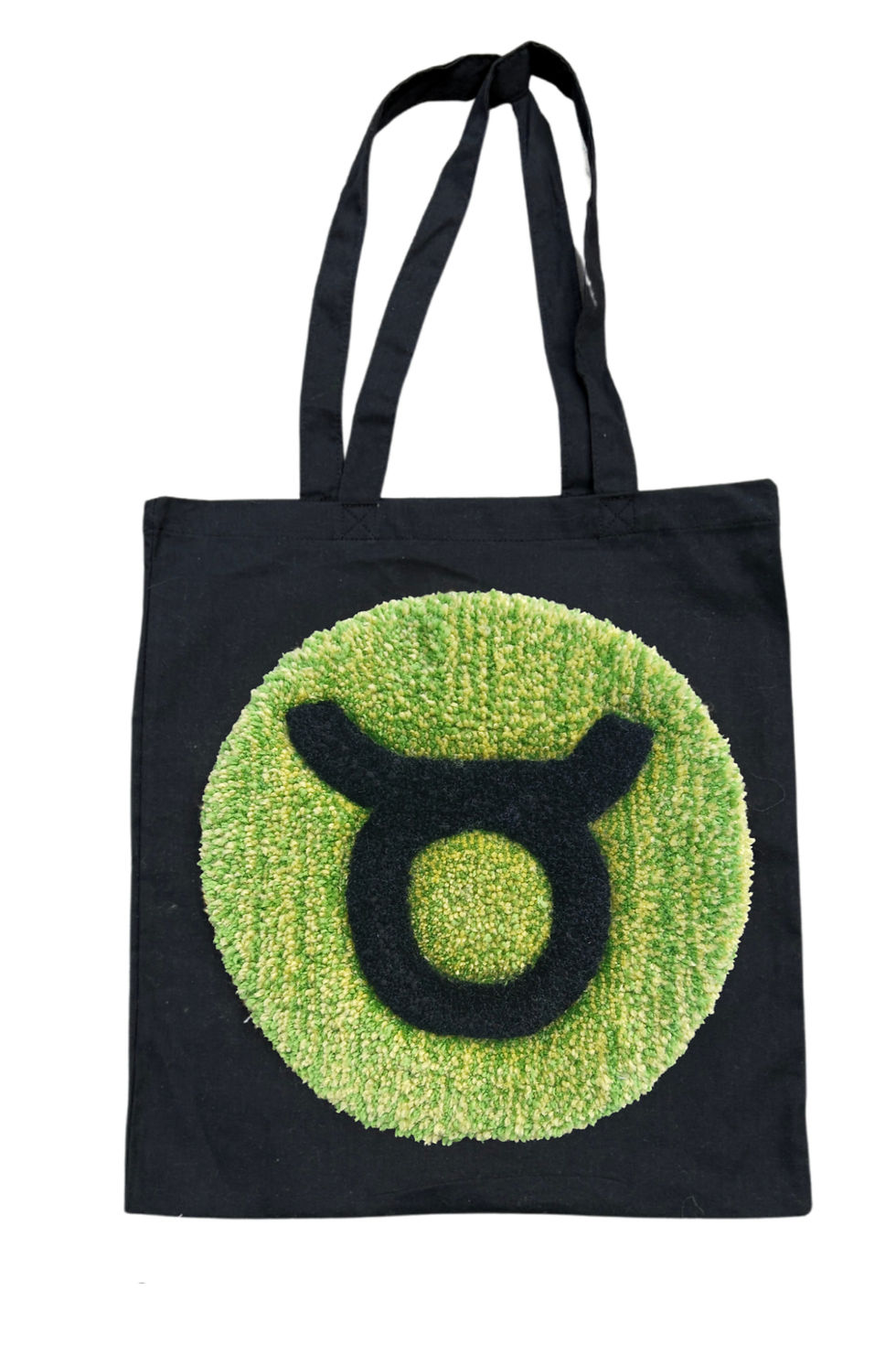 Thumbnail: Hand tufted 33cm diameter circular Taurus Zodiac Sign on a black Tote Bag. www.astralthreads.co.uk