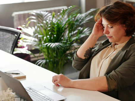 Lady at work feeling tired sat at a desk