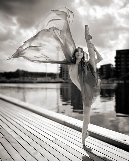 Nude dance photograph portraying fluid movement, with soft lighting enhancing the form and gesture.