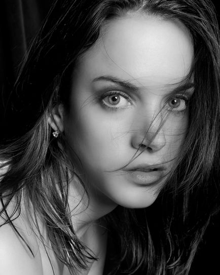 Close-up black and white portrait of woman with hair in her face.