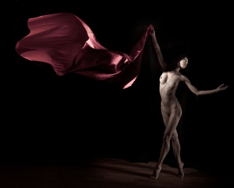 Black-and-white nude dance photograph emphasizing contrast, shadow, and the elegance of the moving figure.
