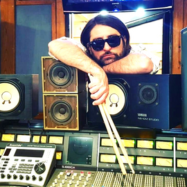 "Donato Scotto di Monaco in studio di registrazione con console SSL e monitor Yamaha. Session drummer e rhythm producer specializzato in drum recording e produzione di groove."