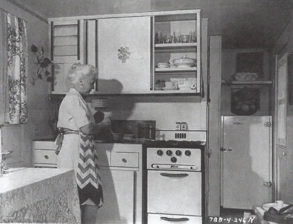 Housewife preparing meal in 1946 in a prefabricated Wingfoot home kitchen.