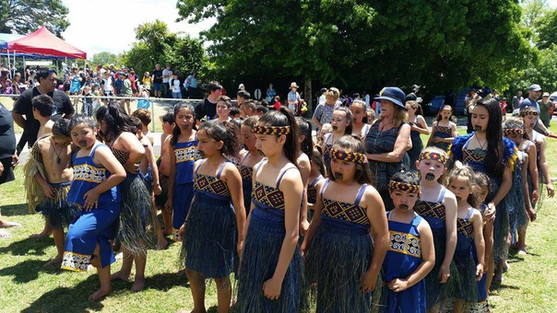 Group of children in traditional dress, performing at a cultural event.