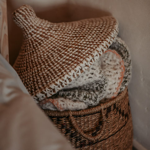 Woonkamer detail met mand en textiel, zachte en natuurlijke materialen