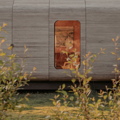 ngang van houten cabin met open deuren in bosrijke omgeving, natuurlijk en rustig vakantieverblijf