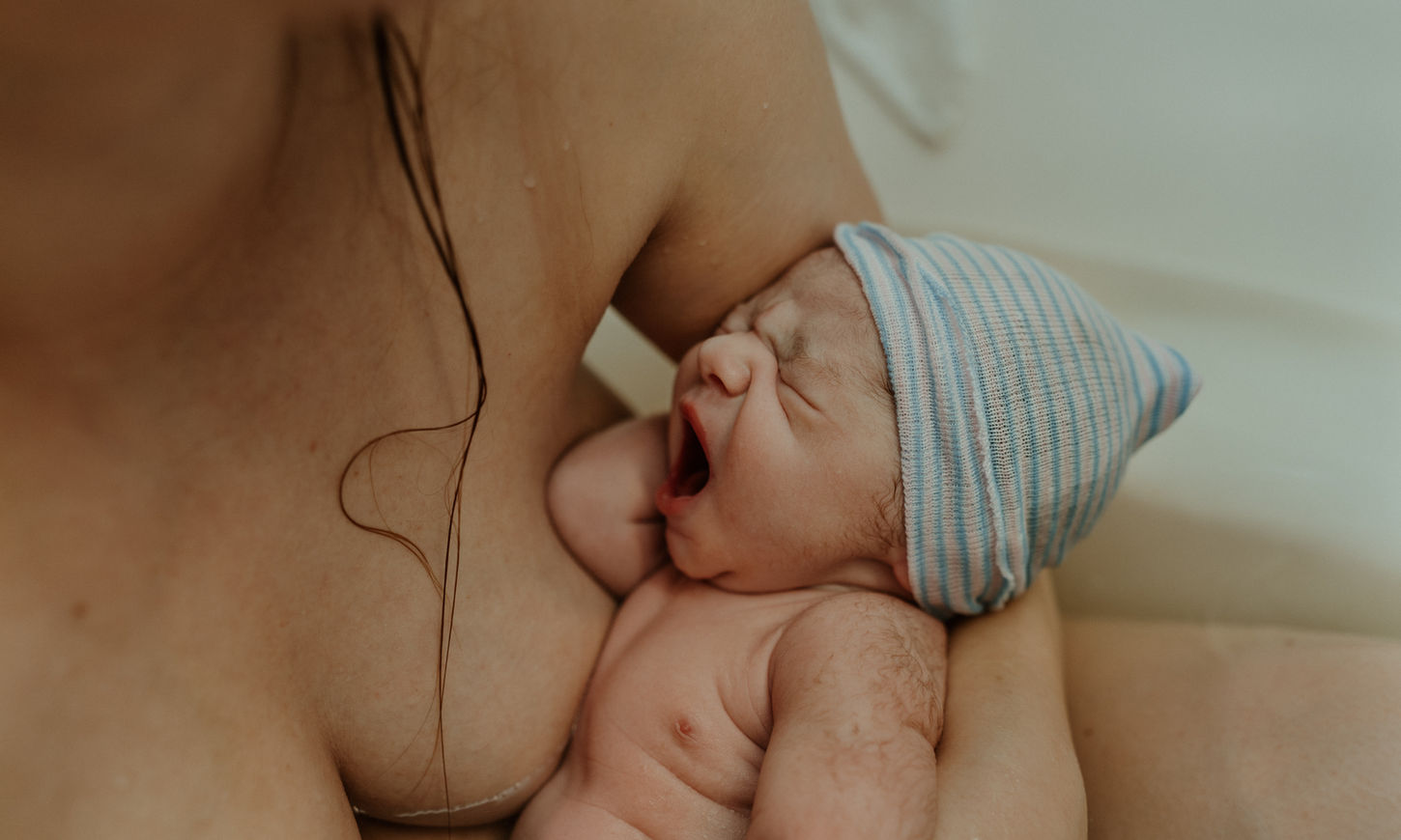 In bad geboren baby Vreugde na badbevalling vastgelegd door Geboortefotograaf