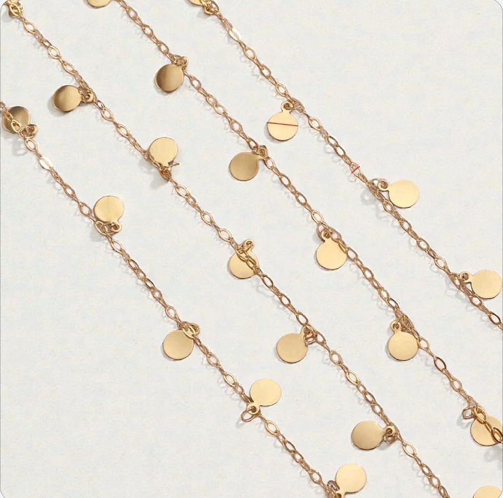 Multiple delicate Gold Disc Chain strands shimmer against a light background.