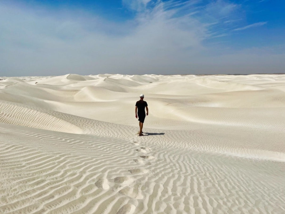 Traveler crossing the white dunes of the Sugar Dunes in southern Oman