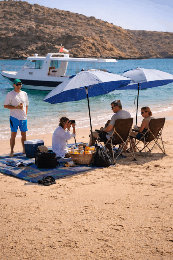 Private beach picnic stop during a Bandar Khairan island hopping experience near Muscat