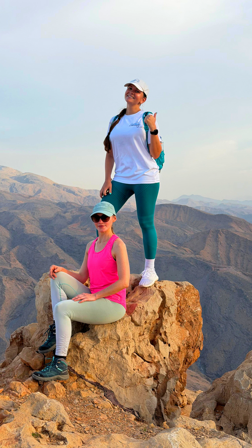 Two hikers posing on a rocky viewpoint along the Sa’al Steps highland trail