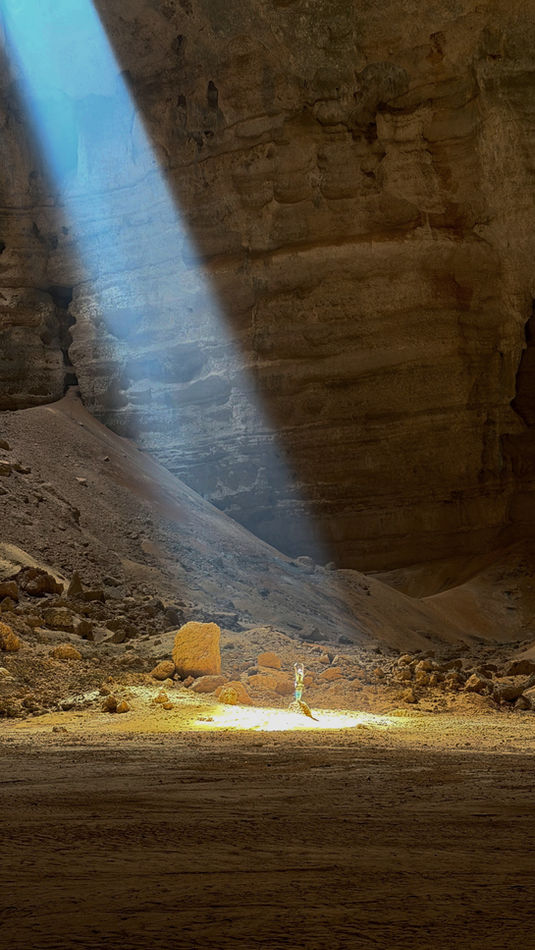Wide underground chamber with sunbeam inside Majlis Al Jinn Cave, Oman