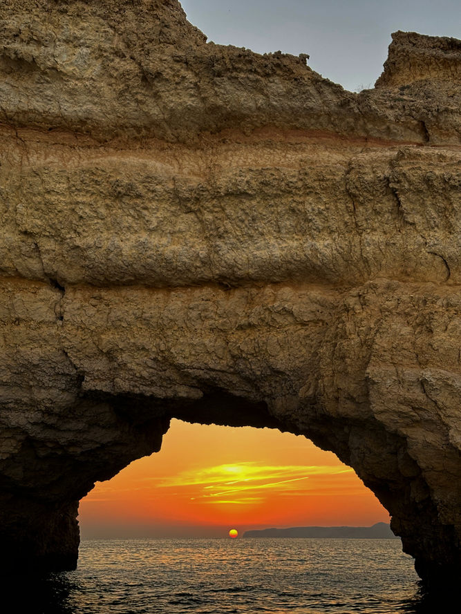 Sunset framed by a natural sea arch during a Bandar Khairan coastal escape in Oman