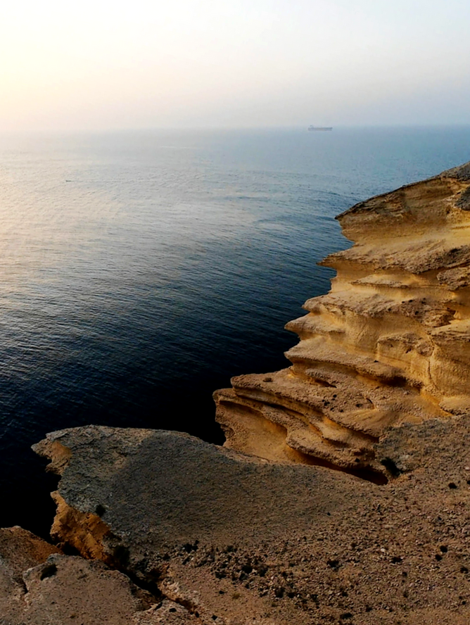 Dramatic sea cliffs and open water views from Al Fahal Island near Muscat, Oman