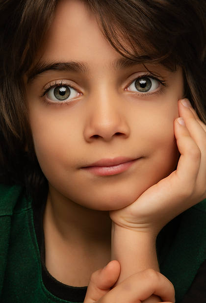 Portrait of a relaxed kid, smiling and leaning over towards the camera 
