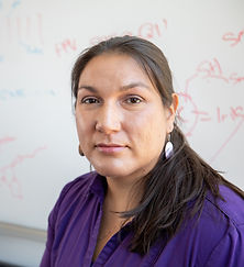 Dr. Lee smiling in a purple blouse and turquoise earrings