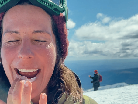 woman at the snow applying sunscreen lip balm to her lips