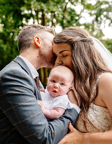 Parents kissing baby on wooden bridge; Cambridge wedding photographer LP WEDDING PHOTOGRAPHY FILM
