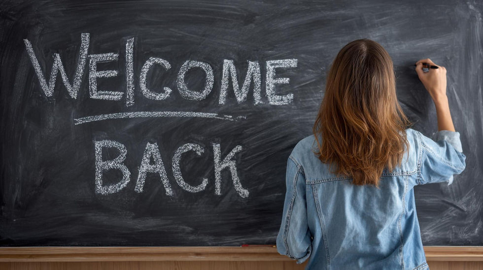woman writing welcome back on a chalkboard
