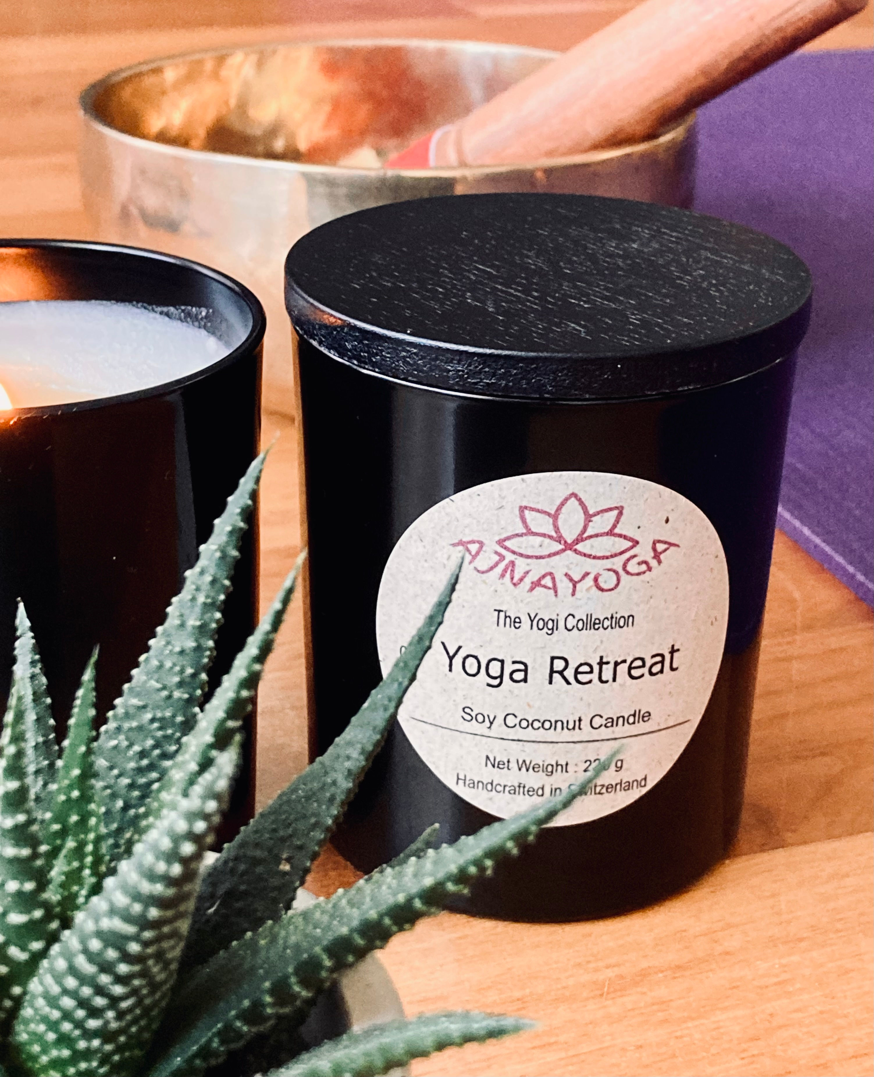 a candle with a plant, a singing bowl and a yoga mat at the background