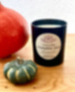 Handmade Pumpkin Spice Coconut Soy Candle for Autumn and Halloween. Two pumpkins as a background