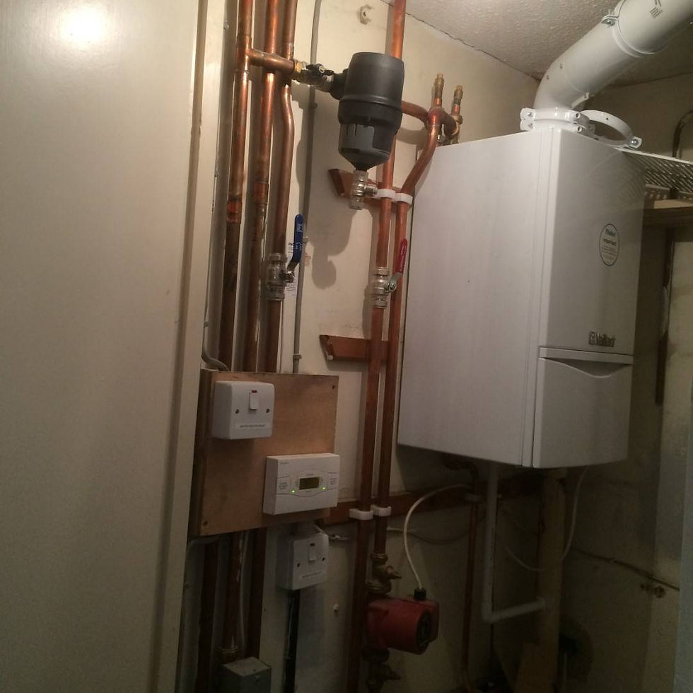 A white boiler with connected pipes installed in a utility room setting.