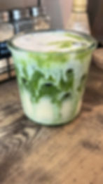 Iced Yakult Matcha Latte topped with vanilla bean sweet cream in a clear glass
