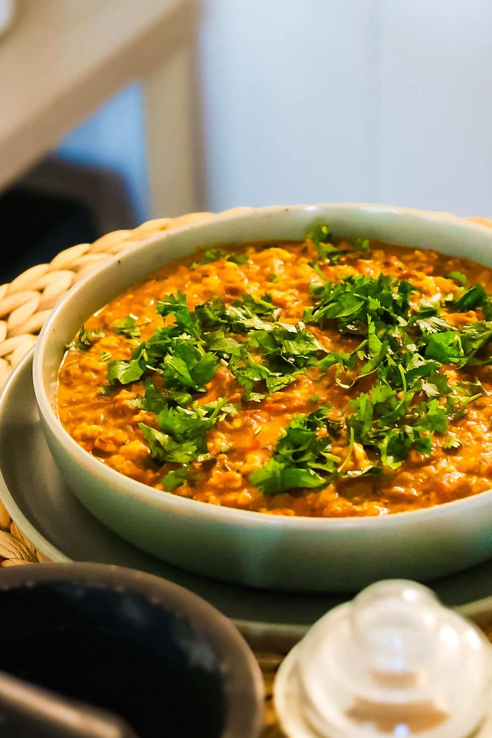 45-degree angle shot of freshly prepared paneer bhurji, garnished with chopped cilantro and served hot in a shallow bowl. Spiced crumbled paneer glistens with golden turmeric, with visible bits of onion, chili, and tomato — a vibrant and hearty Indian breakfast dish.