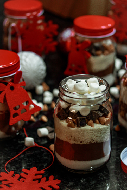 Homemade butterscotch hot chocolate mix in bottles with marshmallows—easy holiday gift idea or winter drink recipe.