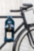 La Bouclée holding a bottle of wine attached to bike in petrol blue colour
