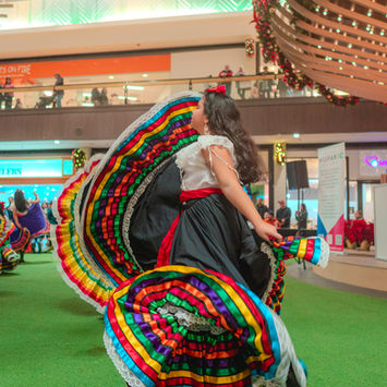 Folklorico dancer in a colorful dress at the marketplace.