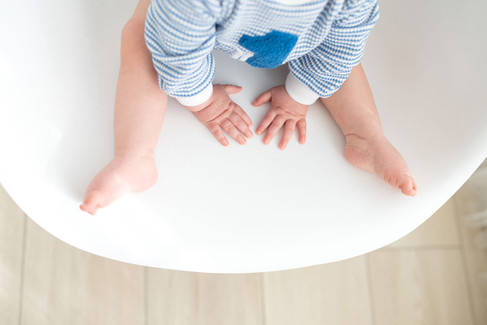 One year old baby boy sitting in a neutral white and cream studio setup in Roseville, soft natural light, minimal styling, and timeless milestone photography by a Sacramento baby photographer.