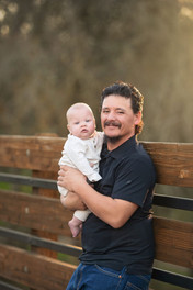 Sacramento family photographer capturing a spring family session with parents and two young boys on a wooden bridge during golden hour in Roseville California.