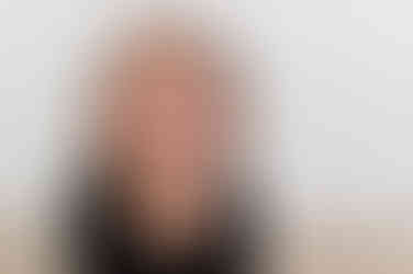 Six month old baby smiling during a milestone session at a Roseville photography studio with simple, clean backdrops.