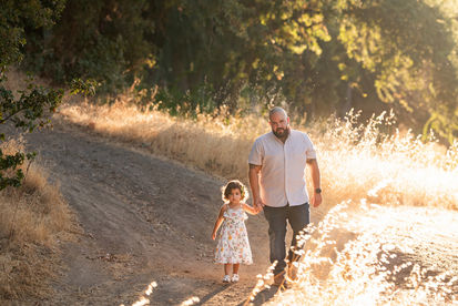 Beautiful maternity session at a Sacramento Ranch in California. Captured by the finest maternity photographer. A mother, her husband, and their shy but sweet daughter during golden California sunset.