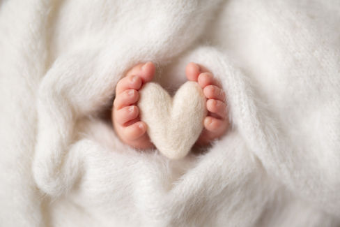 Sweet newborn baby boy peacefully sleeping in a cozy studio setting, wrapped in soft neutrals of cream and white, with delicate details captured like tiny toes, hands, and lashes. Family photos included tender moments with mom and dad. Taken by the best maternity and newborn photographer in Sacramento, Kristina Martin Photography.