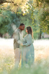 Couple standing together in a forest, with the husband lovingly looking at his pregnant wife taken by Sacramento photographer Kristina Martin Photography.