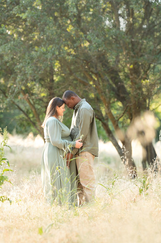 Couple standing close together in a golden field, with soft sunlight filtering through the trees taken by Sacramento photographer Kristina Martin Photography.