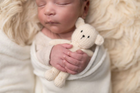 A gallery of newborn session images featuring a swaddled baby in simple, cozy setups. The photos capture a variety of angles, showing the baby peacefully resting in natural, comfortable poses. Some images are taken on a soft white backdrop, while others include a blue background or warm, textured blankets taken by Sacramento Maternity and Newborn photographer Kristina Martin Photography.